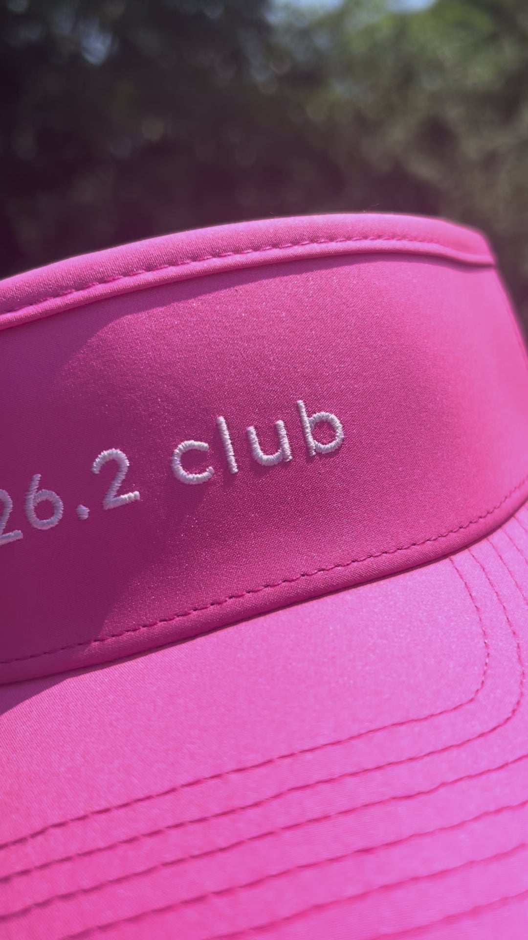 Girl wearing '26.2 club' pink visor outside and showing close-ups